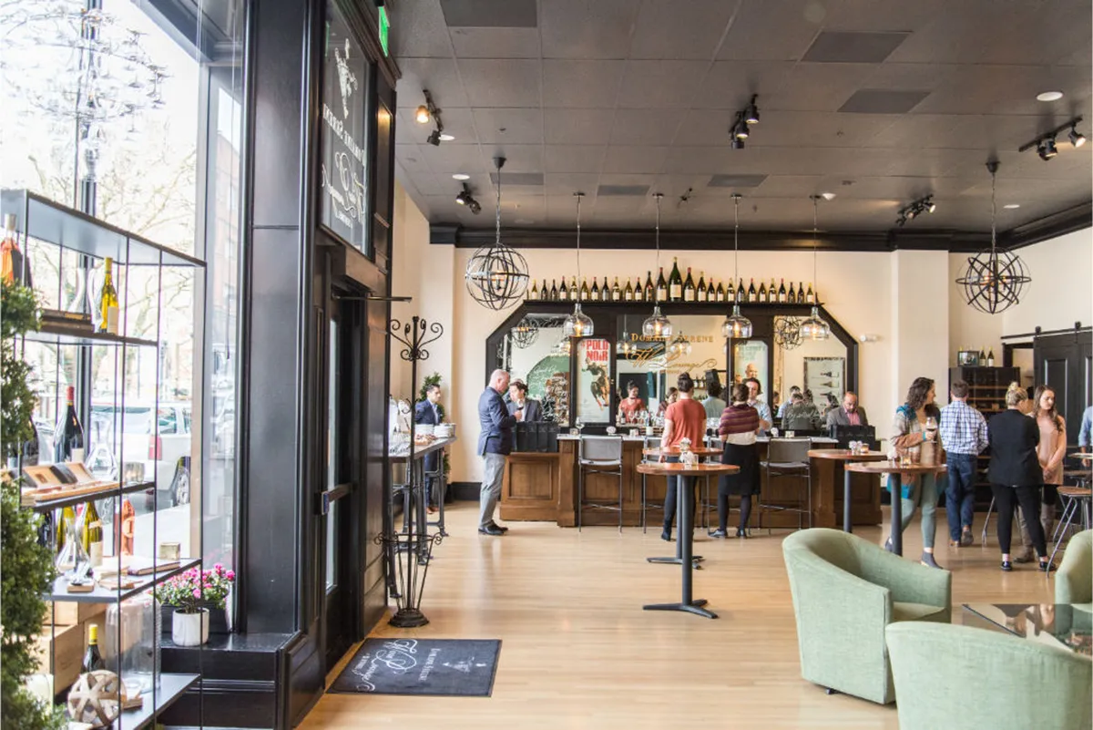 This image captures the hotel's lively bar area, bustling with guests interacting and enjoying drinks. Wine shelves line the walls, and a comfortable seating area invites casual dining and social gatherings. The overall ambiance is inviting and social, highlighting the communal aspects of the hotel's hospitality experience.
